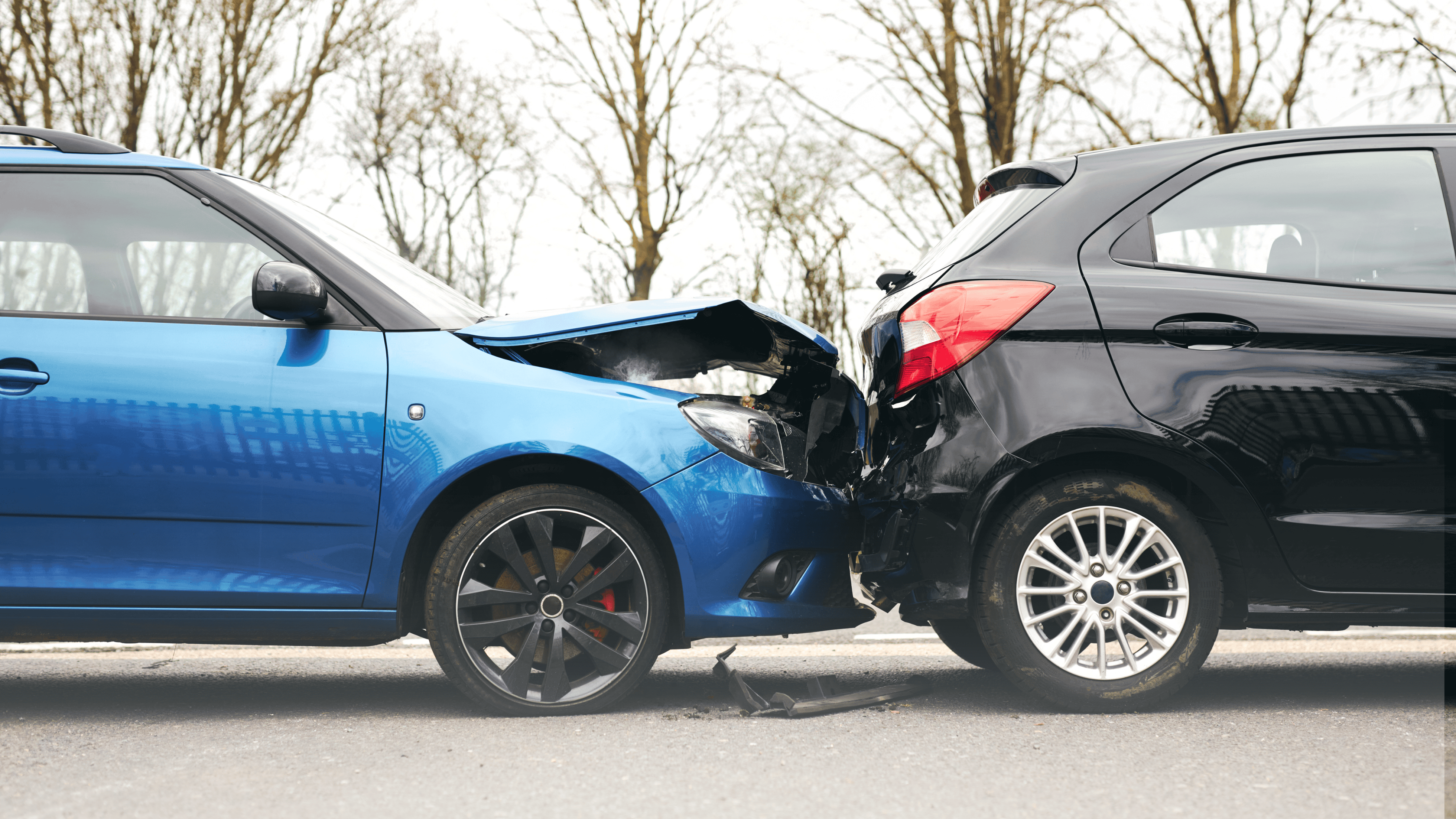An image of two cars directly after a collision. A blue car rear-ended a black car, resulting in its hood being bent up.