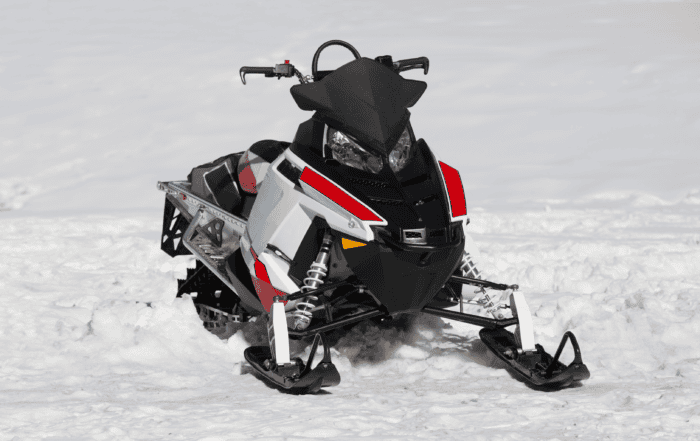 Image of a snowmobile sitting still on a snowbank.